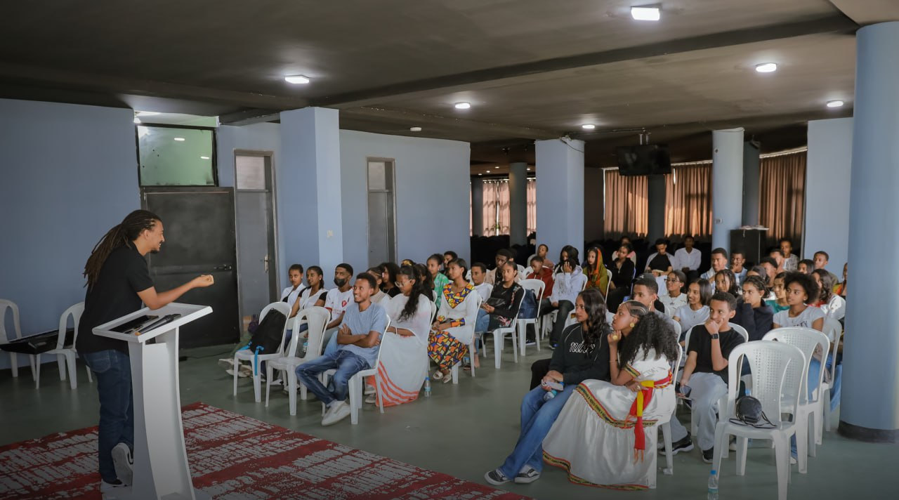 A full hall of students listening to a sermon